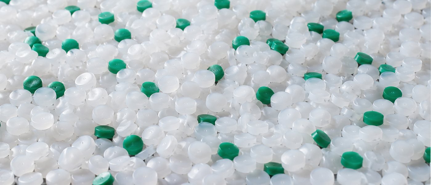 Natural polypropylene granules with green masterbatch pellets mixed through